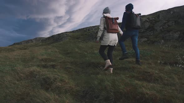 Young Loving Couple Walking in Field on Background of Epic Dramatic Clouds Slow Motion