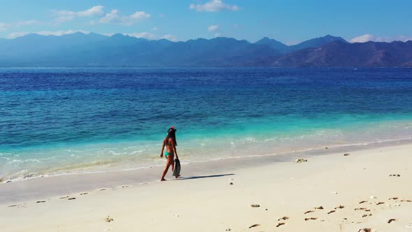 Sexy smiling ladies on vacation spending quality time at the beach on sunny blue and white sand 4K b