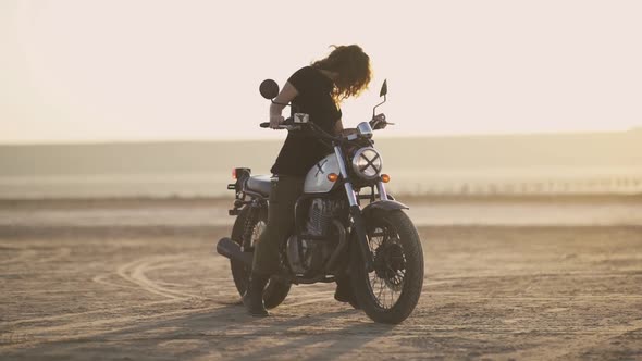 Attractive Young Woman Motorcyclist Makes a Burnout on a Motorcycle and Ride Away