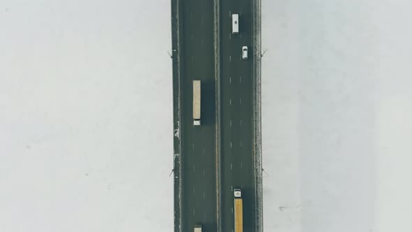 Huge Lorries and Small Cars Drive Along Wide Highway Bridge