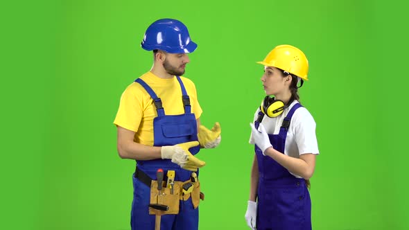 Pair of Professional Builders Are Talking Among Themselves. Green Screen