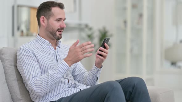 Ambitious Young Man Celebrating Success on Smart Phone