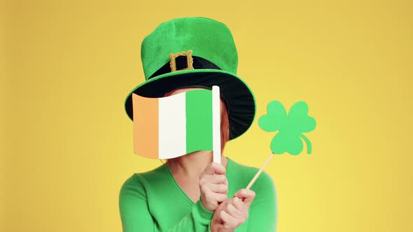 Woman with leprechaun's hat, Irish flags and clover shaped banner