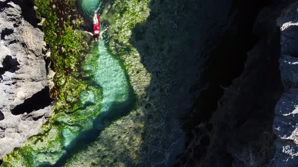 Top Down View on Girl in Natural Pool Between Rock