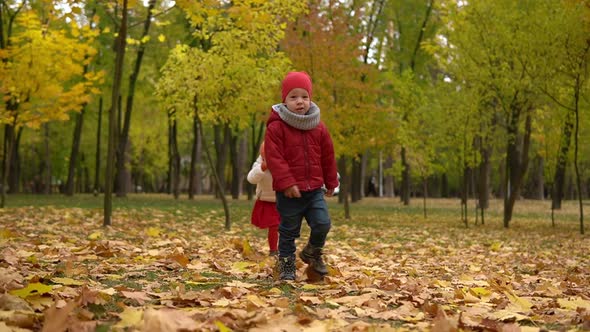 Two Happy Funny Children Kids Boy Girl Walking in Park Forest Enjoying Autumn Fall Nature Weather