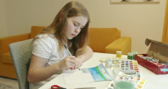 Girl Coloring Painting at Table