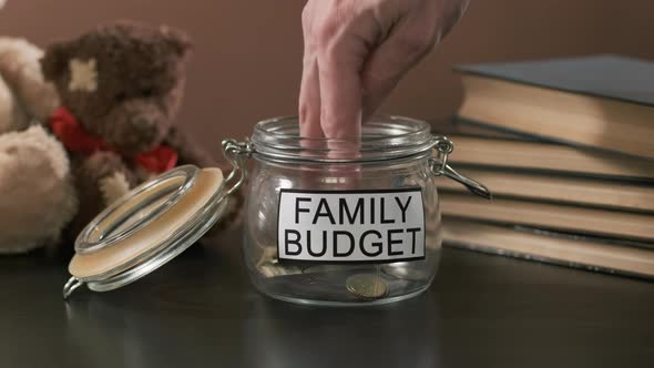 Closeup of Man Taking Family Savings From Glass