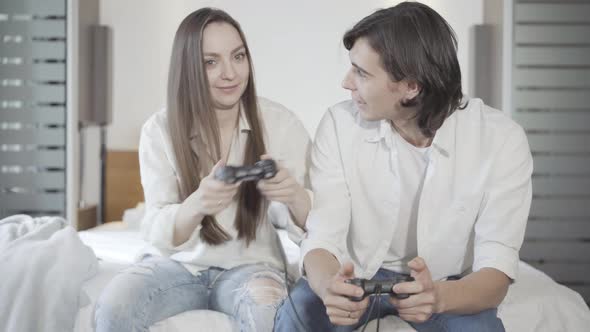 Cheerful Millennial Couple Playing Video Games Indoors. Portrait of Joyful Young Caucasian Man and