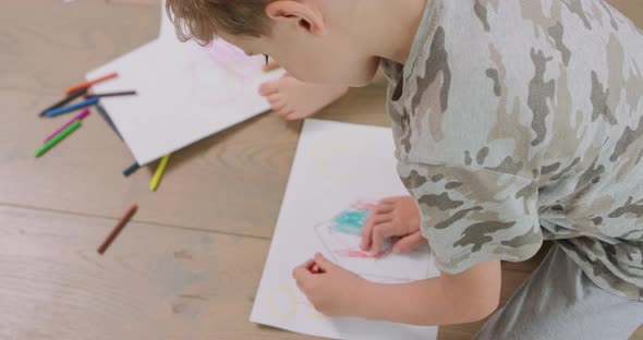 Close Up of a Hands and Feet of a Little Boy and a Little Girl Who are Drawing with Pencils on the