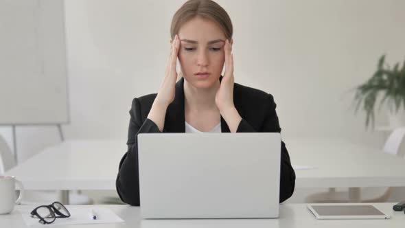 Stressed Young Businesswoman with Headache Working on Laptop