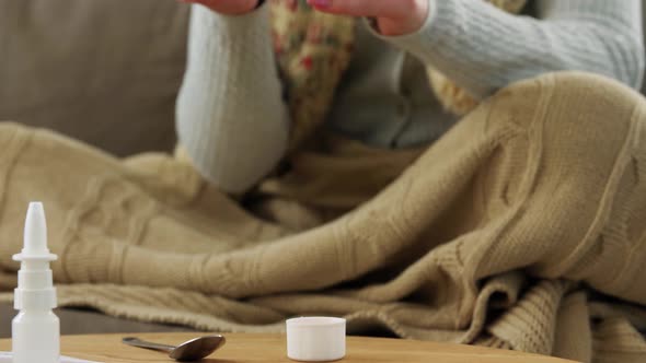 Sick Woman in Scarf Drinking Cough Syrup at Home