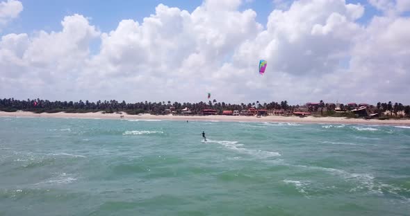 Aerial drone view of a woman kiteboarding on a kite board.