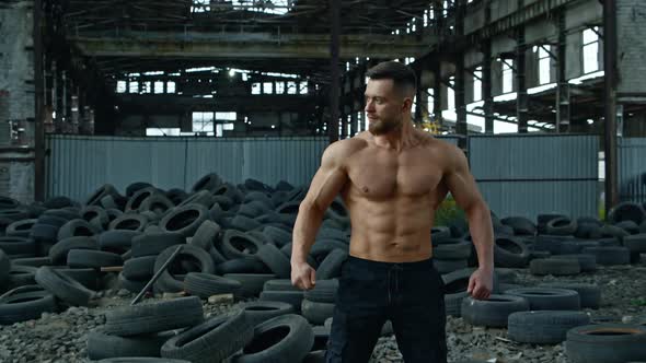 Portrait of bodybuilder in ruined factory. 