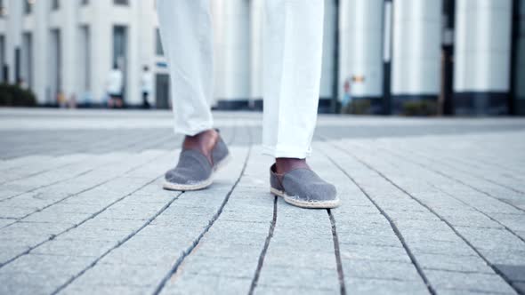 African American street dancer legs in grey shoes perform dance steps