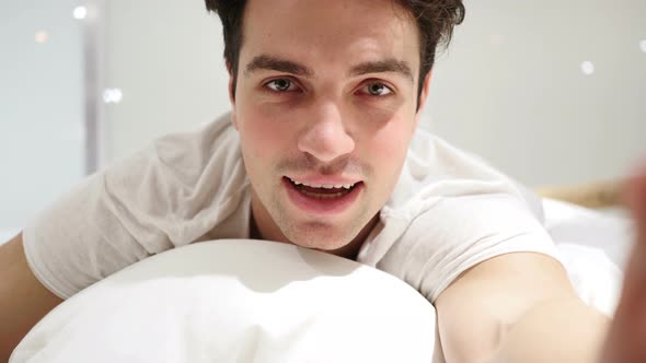 Online Video Chat by Man Lying in Bed