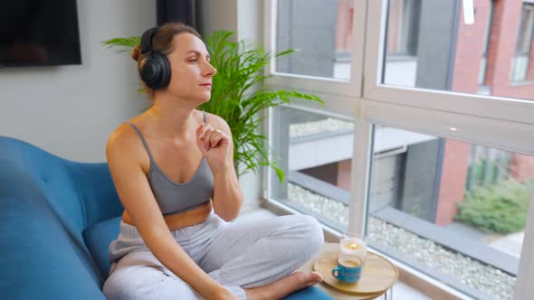 Woman in Wireless Headphones Listening to Music and Using Mobile Apps or Communicates on Social