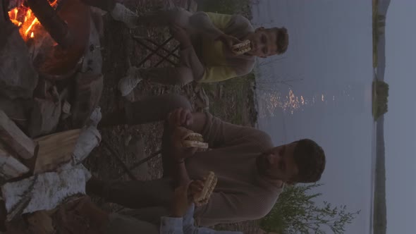 Family Eating Hot Dogs by Lake