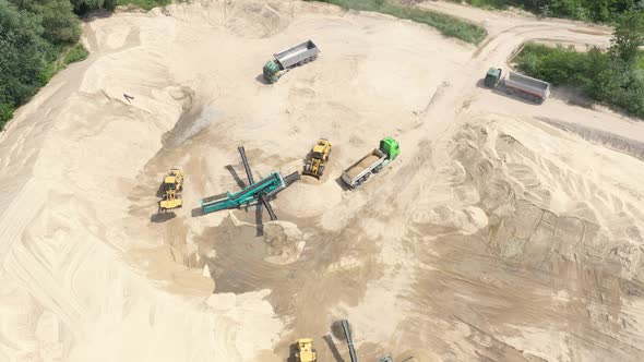 Aerial view loading bulldozer in open air quarry. Sand loading