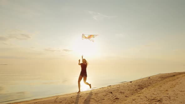 Happy Young Woman Running with a Kite