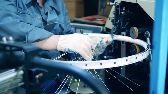 Engineer Is Putting Spokes Into a Bike Wheel