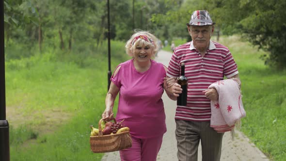 Family Weekend Picnic. Active Senior Old Grandparents Couple in Park. Husband and Wife Walk Together