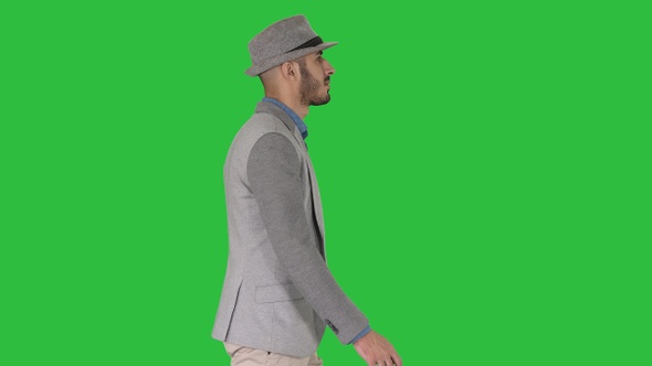 Casual arabic man in hat walking on a Green Screen, Chroma Key.