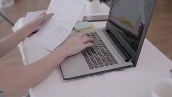 Business Asian woman type note job on laptop in living room.Work from home.