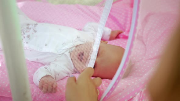 Mother and baby in portable bassinet outdoor / Videohive