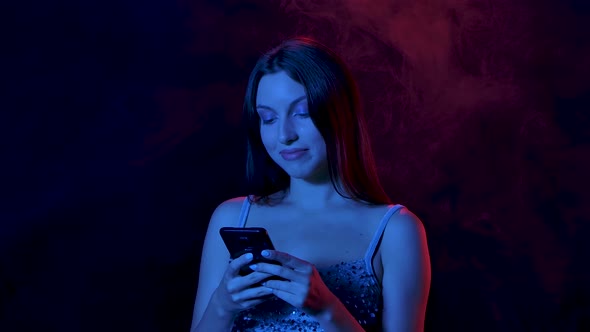 Portrait of Charming Young Woman Is Texting on Her Phone Then Shows Smartphone with a Green Screen