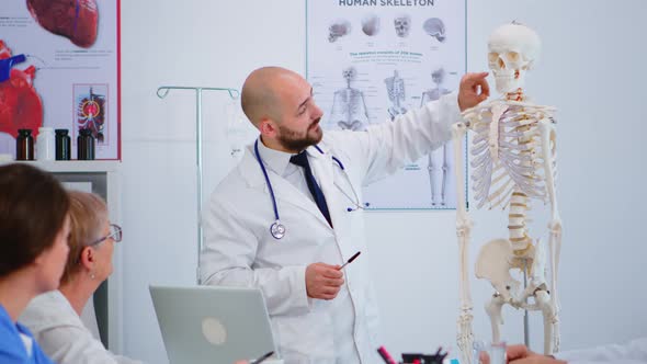 Specialist Doctor Showing Body Bone Functionson Using Skeleton Model