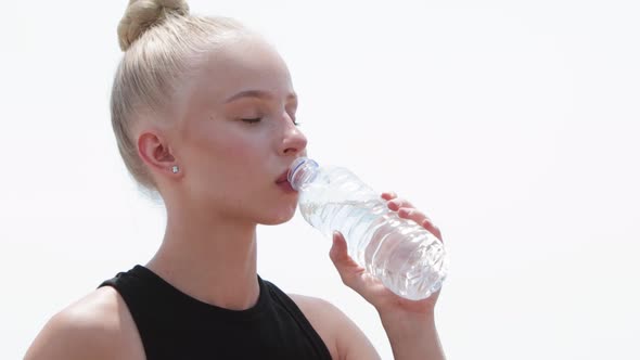 Young Blonde Woman Drinks Water From Plastic Water