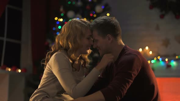 Awesome Tender Couple Hugging Near Sparkling Christmas Tree, Celebrating Holiday