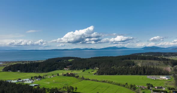 Aerial shot of Whidbey Island's farm land with the San Juans off in the distance.