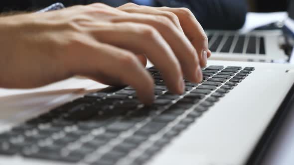 Close Up to Male Hands of Entrepreneur Typing Text on Notebook Keyboard at Office