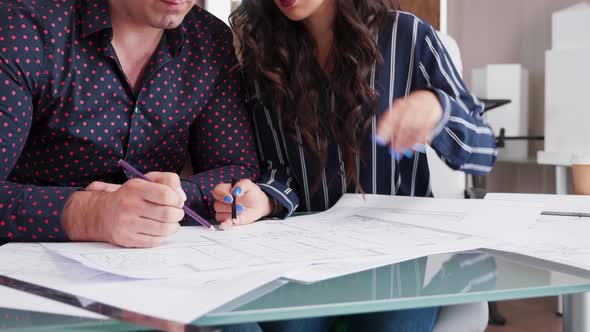 Close Up of Architects Drawing on Blueprints in the Office