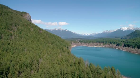 Cascade Mountain Range Dusted With Snow In Aerial Flying Over Turquoise Lake