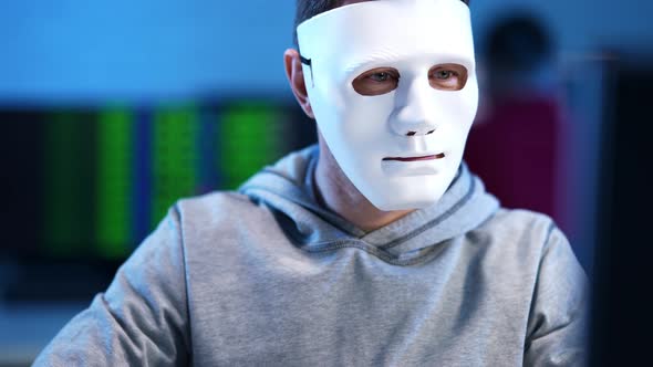 Young Brunette Man in Face Mask Hacking Website Indoors