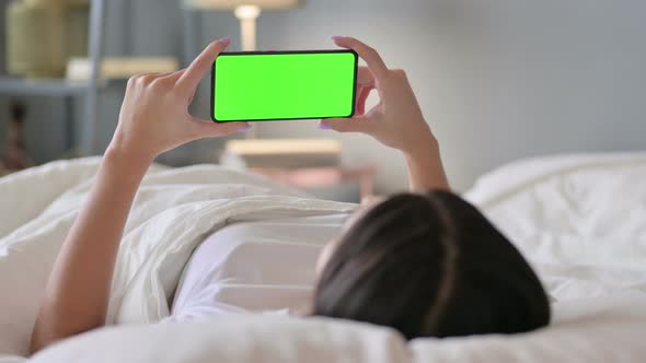 Latin Woman Watching Green Screen of Smartphone in Bed, Chroma Screen 