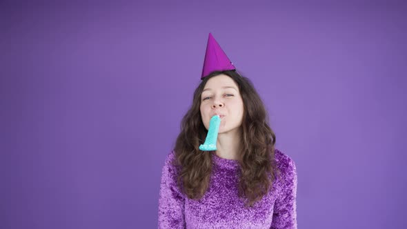 Woman in Birthday Cap Blowing Squeaker Celebrates Holiday