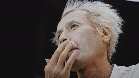 Mime Puts White Paint on Face Preparing for Performance