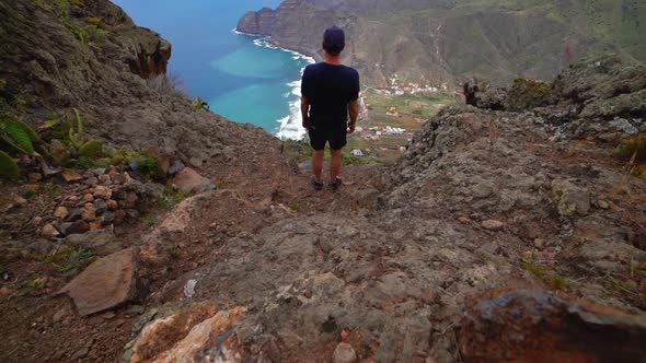 Man On Mountain Looking At Coastline And Sea