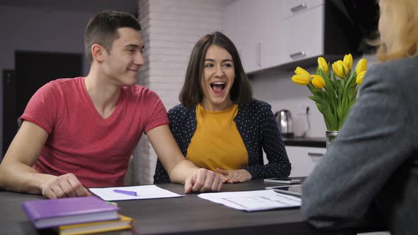 Cheerful Couple Signing Contract with Estate Agent