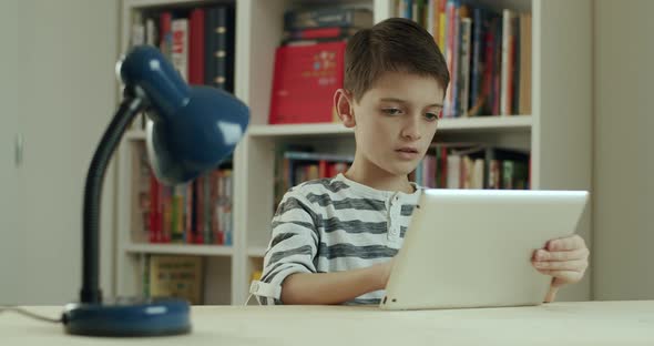 Boy Working at Home on Digital Tablet