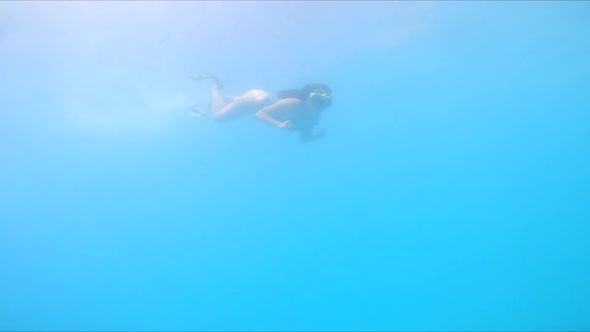 Woman in Flippers Diving Underwater