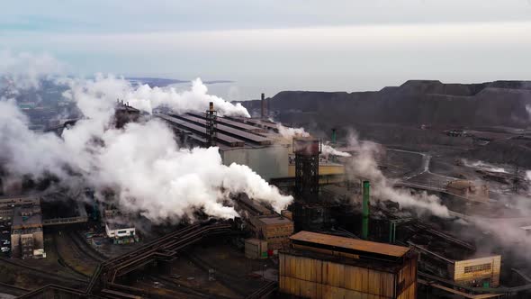 Aerial. GLOBAL WARMING. View of High Chimney Pipes with Grey Smoke. Pipes Pollute Industry