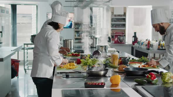 Female Cook Chopping Bell Peppers on Cutting Board