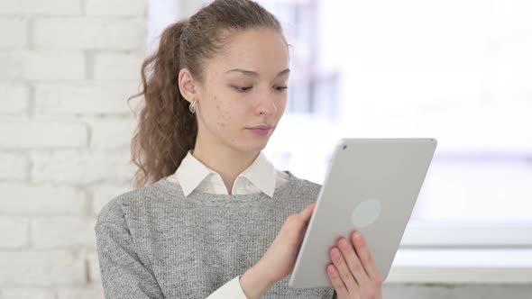 Portrait of Serious Young Latin Woman Using Tablet