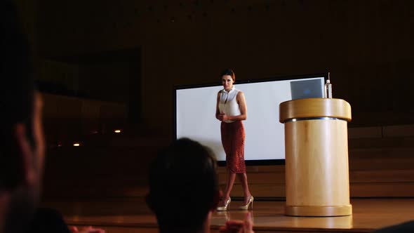 Audience applauding speaker before conference presentation