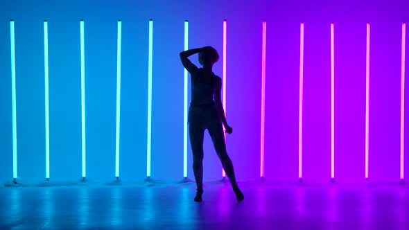 Artistic Lady Showcases Street Style Choreography Against a Backdrop of Multicolored Neon Tubes