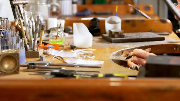 Goldsmith working at desk in workshop 4k